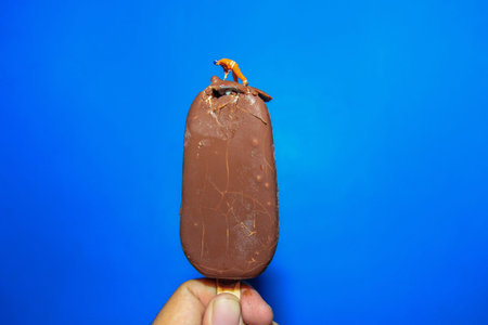 miniature worker on ice cream with blue wall background