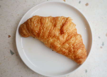 Croissant on a white porcelain plateの写真素材