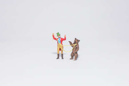 Miniature circus performer with a bear , isolated on white backgroundの写真素材