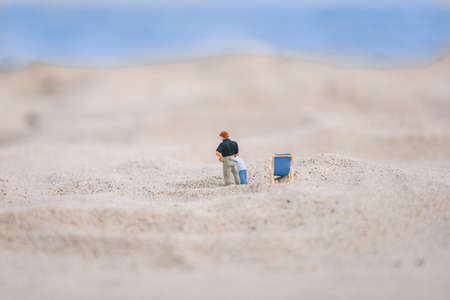 Miniature father and son walking down the beachの写真素材