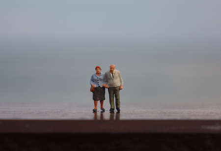 A pair of grandparents standing edge of the seaの写真素材