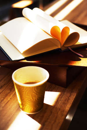 Notebook with violet flowers on a wooden abstract background.Book opens with a purse on a wooden background.の写真素材