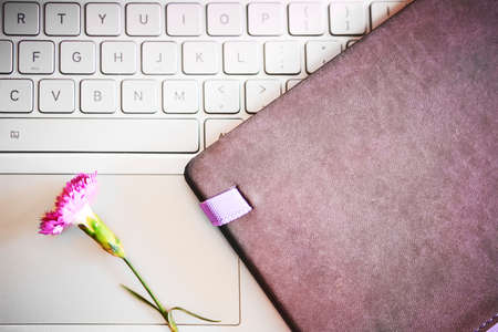Notebook with violet flowers on a wooden abstract background.Book opens with a purse on a wooden background.の写真素材