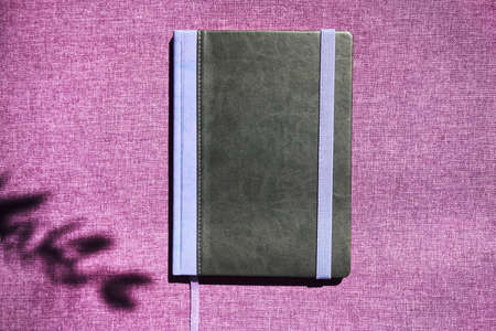 Notebook with violet flowers on a wooden abstract background.Book opens with a purse on a wooden background.の写真素材