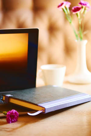 Notebook with violet flowers on a wooden abstract background.Book opens with a purse on a wooden background.の写真素材