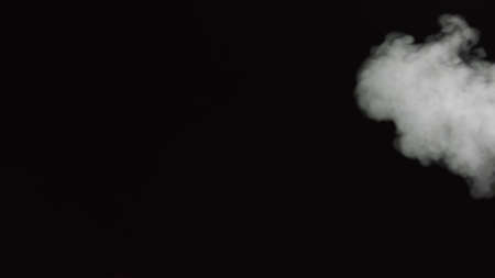 White water vapour on a black background. Close-up shot. White Fume Slowly Floating Rises Up. Abstract Haze Cloud. Animation Mist Effect. Smoke Stream Effect 4Kの写真素材