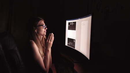 Young concentrated woman, sitting in her room or office .Studies late at night.Staying up late. Woman feeling headache and pain in the neck.の写真素材