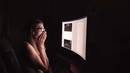 Young concentrated woman, sitting in her room or office .Studies late at night.Staying up late. Woman feeling headache and pain in the neck.の写真素材