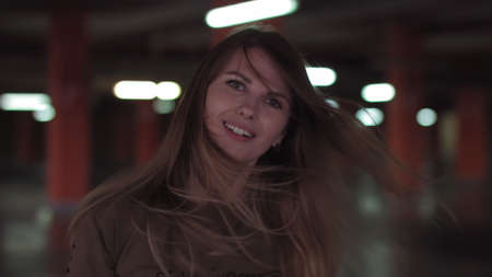 Beautiful woman with a magnificent hair. Fun happy young girl shake her head to make hair flying. Attractive young lady turns around and looks into the cameraの写真素材