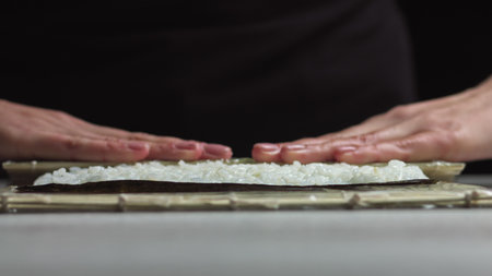 Sushi Chef Spreading Japanese Sushi Rice On Nori Sheet For A Delicious Sushi Rolls. - high angle...