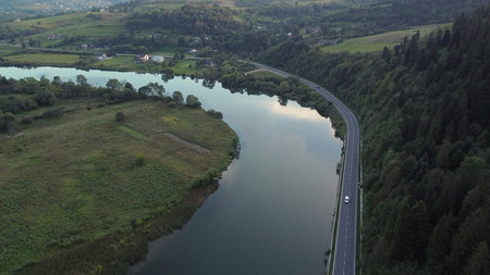 Beautiful View of Scenic Road by River at Sunset. Aerial Drone Shot. Northern Rocky Mountains, Ukraineの写真素材