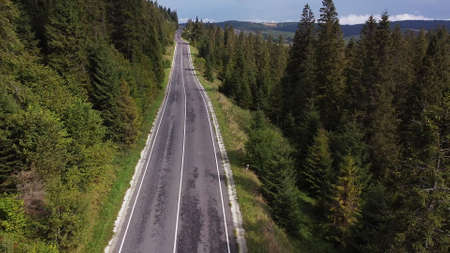 Aerial shot serbia. Drone flight over the mountains over the road that winds between the mountains with a beautiful view of green trees and cliffs.の写真素材
