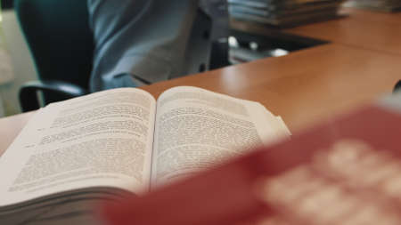 Serious young businessman checking corporate paperwork correspondence sitting at home office desk. Male entrepreneur reading documents, analyzing financial papers, preparing audit report at workplace.の写真素材