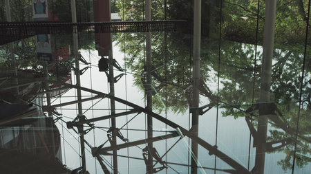 A young handsome man in an architect or lawyer suit walks around a modern office. Reflection in a...
