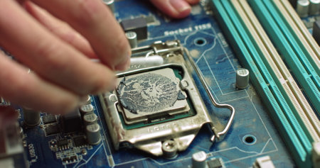 The repairman cleans the CPU of the laptop from the old thermal grease. Electronics and computer concepts service. Repair of computer boardsの写真素材