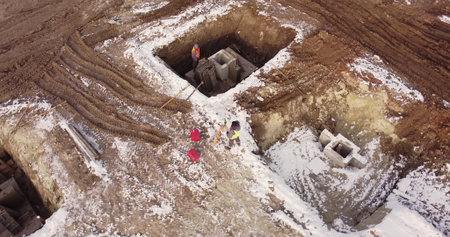 Construction Worker Using Theodolite Surveying Optical Instrument for Measuring Angles in Horizontal...