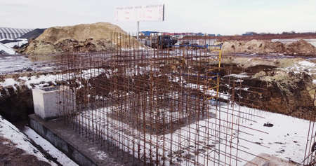 Building workers are constructing a metal framework. Workers working on the construction site removed from the drone. Builders build a house. View from the quadcopterの写真素材