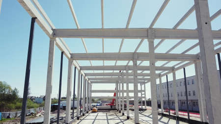 Framework On The Construction Site Of Modern Architecture Office Or Commercial Building Made Of Steel Reinforced Concrete. Flight Over The Construction Site. Beams With Steel Reinforcement From Above.の写真素材