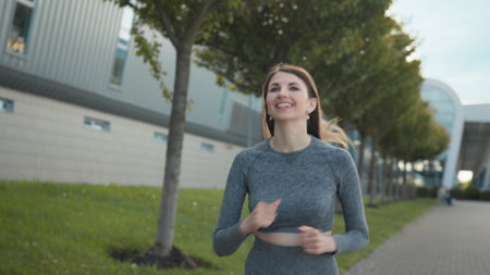 Young woman runner training in summer park city. Portrait of young and fit woman running and jogging...