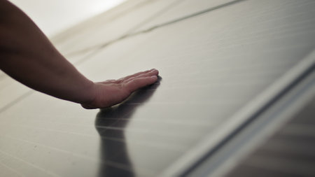 Close up of a young engineer hand is checking the operation of sun and cleanliness of photovoltaic solar panels on a sunset. Concept.renewable energy, technology, electricity, service, green, future.の写真素材