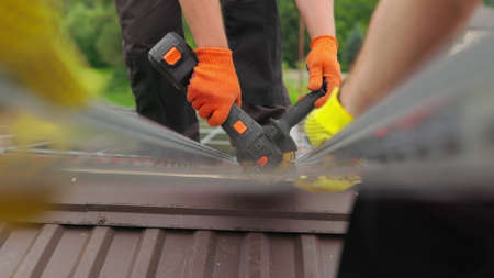 Slow motion of construction worker cutting steel beam. Man works circular saw. Flies of spark from hot metal. Man worked over the steel. close-up of hand and electric saws metal. Close-up of hand tooの写真素材