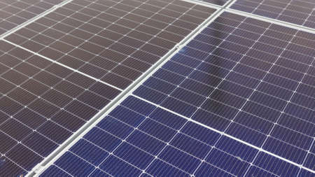 Close-up of modern photovoltaic solar battery. Rows of sustainable energy solar panels installed on farmland meadow rural field. Concept for ecology. Solar Panel Array.の写真素材