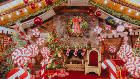 Red post box for letters to Lapland to Santa Claus. Christmas tradition. Decorative mailbox Santa Claus workshop, wrapped gifts presents boxes on holiday eve in night on xmas backgroundの写真素材