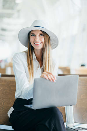 happy woman using laptop computer at airport.の写真素材