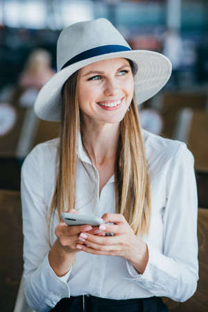 charming lady is sitting on bench at airport.の写真素材