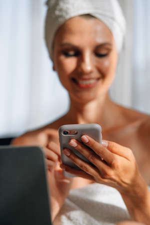 Woman looking on mobile screen and gesturing for expressing happiness. Good news, emotions and technology concept. Woman looking on mobile screen. Winning in the mobile application, jackpot.の写真素材