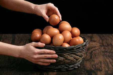 woman getting an egg out of a basketの写真素材