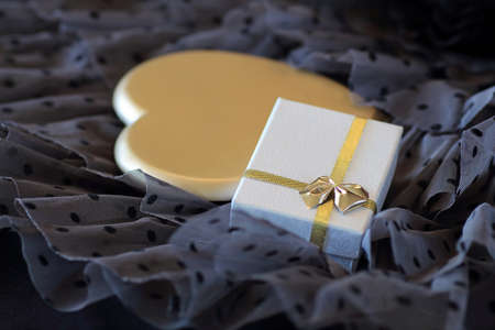 Romantic background with a gift and a heart of goldの写真素材
