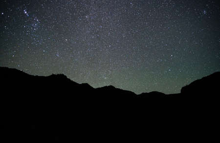 Horizontal shot of starry night sky with mountain silhouette in Chileの写真素材