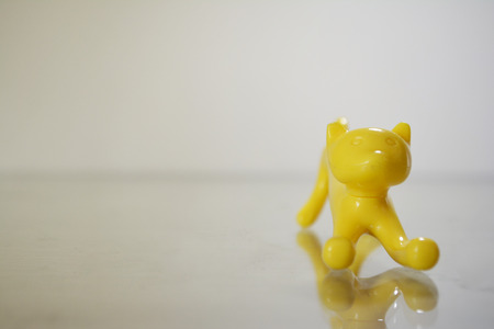 a yellow toy cat with a white backgroundの写真素材