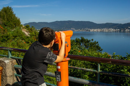 Child, from the back, observing the view of Lagoa da ConceiÃ§Ã£o, with a viewfinder, in FlorianÃ³polis, Santa Catarina, Brazil. Photo obtained from the viewpoint of Morro da Praia Mole in June 2023の写真素材