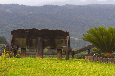Photo of a wooden bench on the side of hills. Photo taken at the back of the bench. Photo captured in November 2024, in Santa Catarina, Brazil.の写真素材