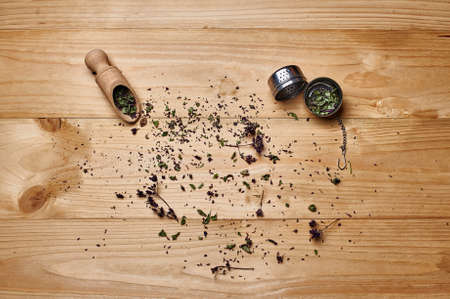 Top view on tea on the pile of dried tea herbs on the wooden backgroundの写真素材