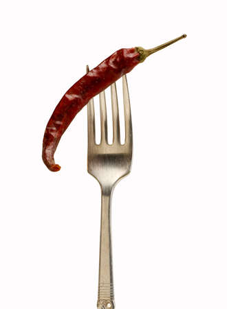 red hot chilli pepper on a fork isolated on whiteの写真素材