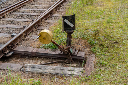 Hand switch with lever, weight and signal and old train tracksの写真素材