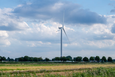 Hamburg, Germany - 07 04 2022: view of a grain field with a Hamburg Energie wind turbine in front of...