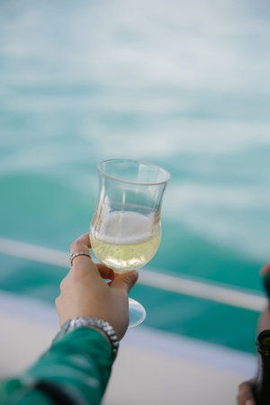 Hand of a lady holding a glass of champagne in a boat party in Jomtien, Chonburi, Thailand