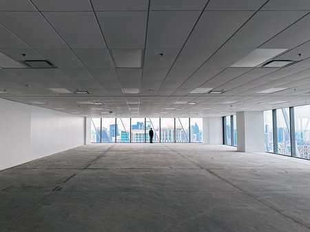 Unrecognizable man silhouette in an empty office space looking at the skyline; business, leadership...