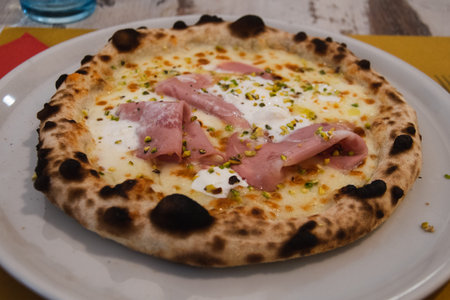 Ham and cheese pizza in a table in a restaurant of Turin