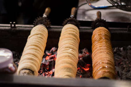 Trdelnik rolls grilled in a market place in a winter night in Pragueの写真素材