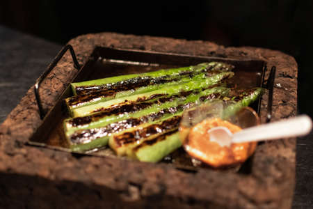 Grilled asparagus with orange sauce ready to be served in a restaurantの写真素材