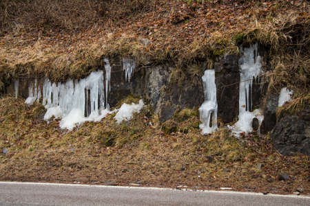 Ice stalactites next to a mountain road in the middle of the Dolomiteの写真素材
