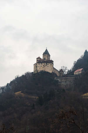 Abandoned castle on top of a hill during a foggy morning in the Dolomiteの写真素材