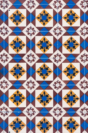 Beautiful and colorful wall made of tiles in Porto, Portugal. It follows a pattern of blue, yellow...
