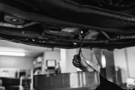 Hands of a Mechanic changing the oil of the car. Black and white. Automobile mechanics conceptの写真素材