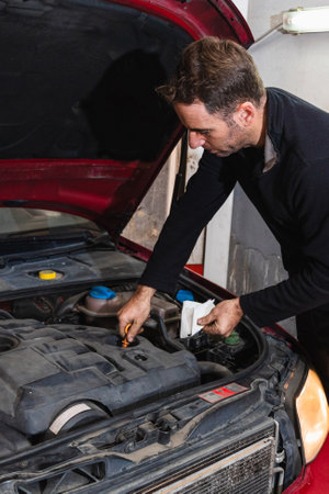 Mechanic looking at oil level in the engine of the car. Concept of automobile mechanicsの写真素材